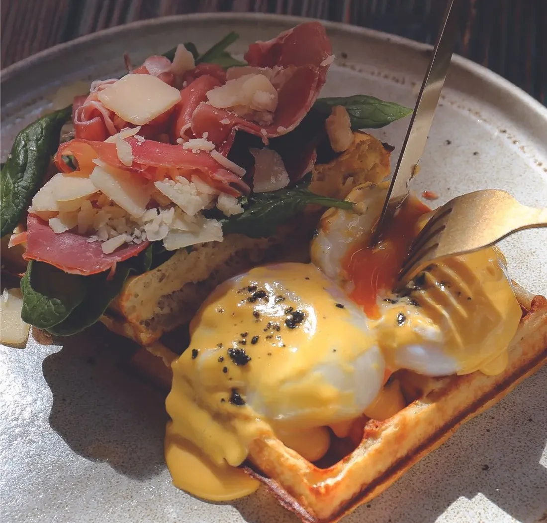 Prosciutto benedict waffle with poached eggs and hollandaise